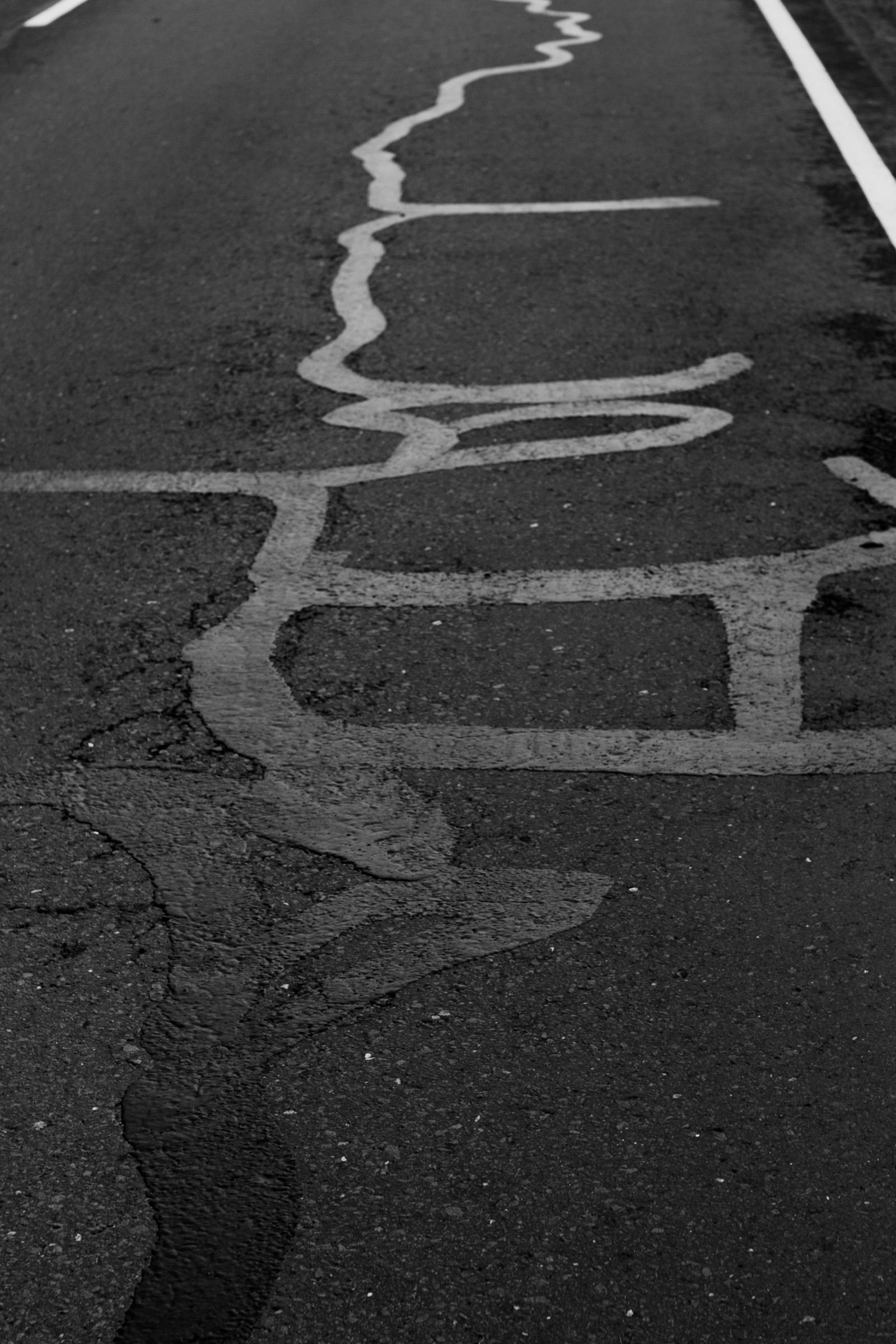 Close-up of asphalt road with visible patch repairs