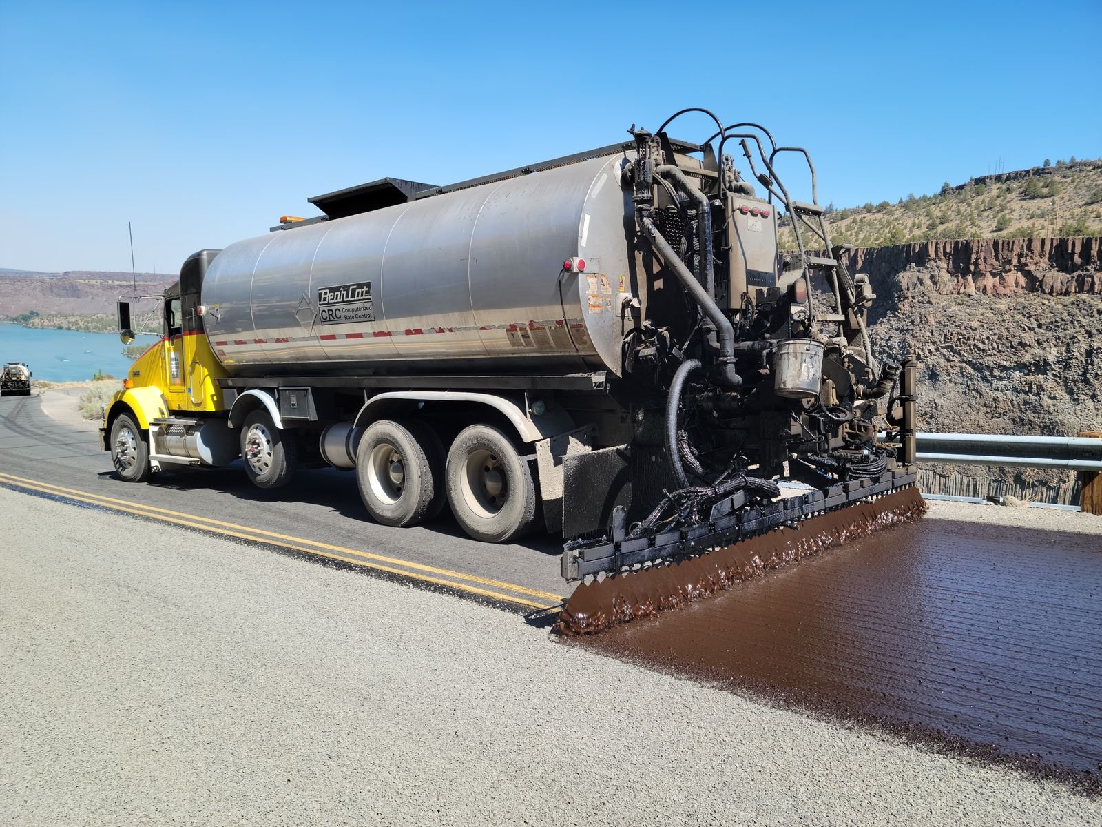 Truck applying seal coat to asphalt pavement